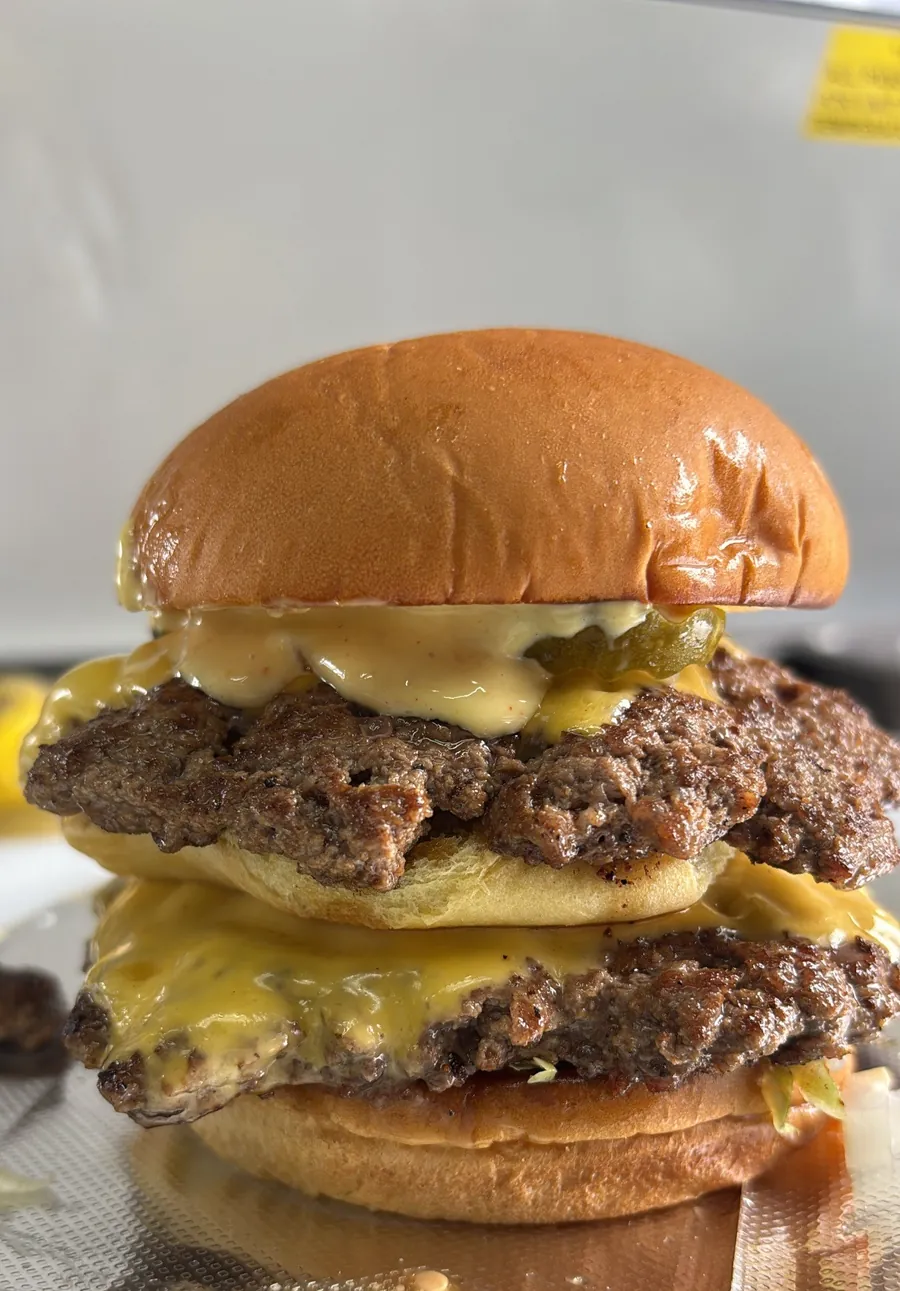 A double smashburger with melted cheese and sauce